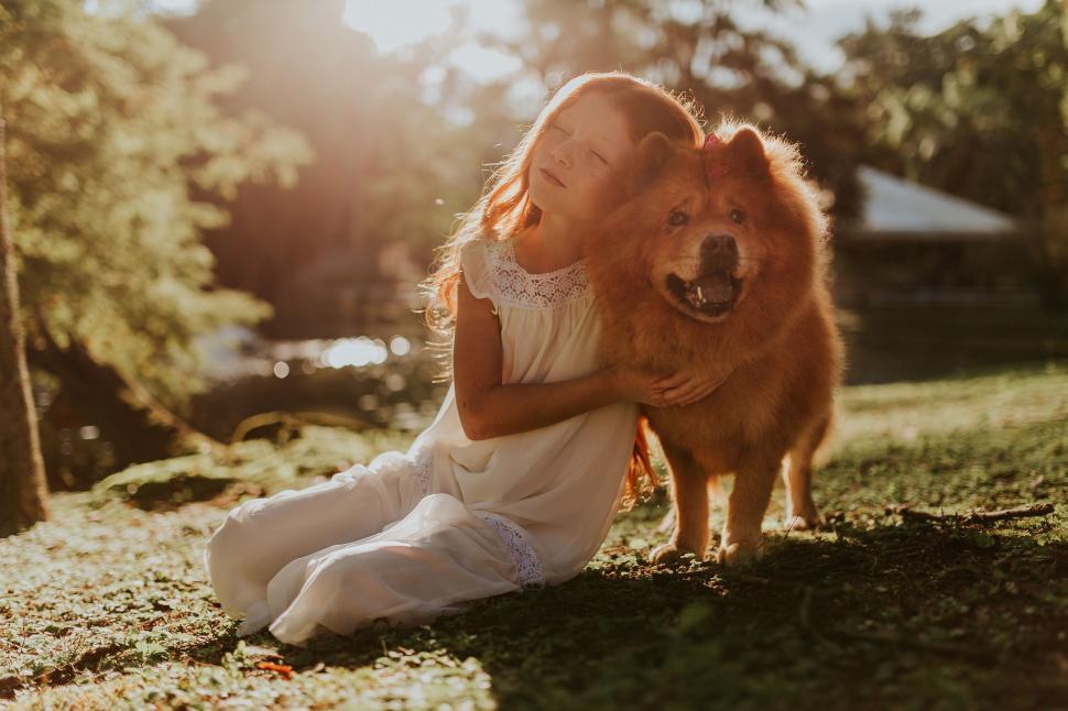 Free Image of Woman in White Embracing a Fluffy Dog 