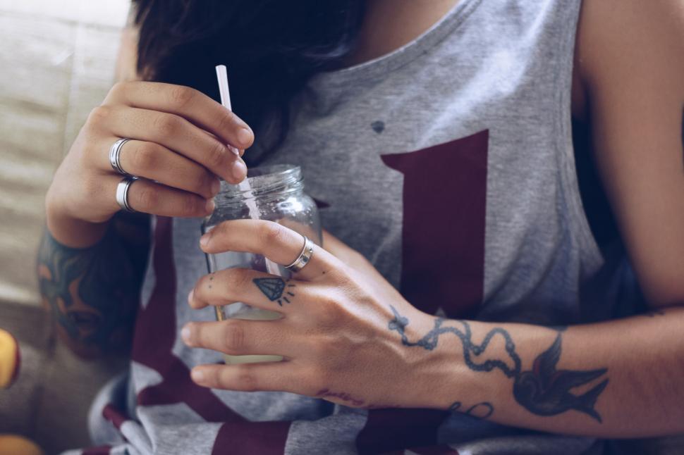 Free Image of Close-up of tattooed hands holding a jar 
