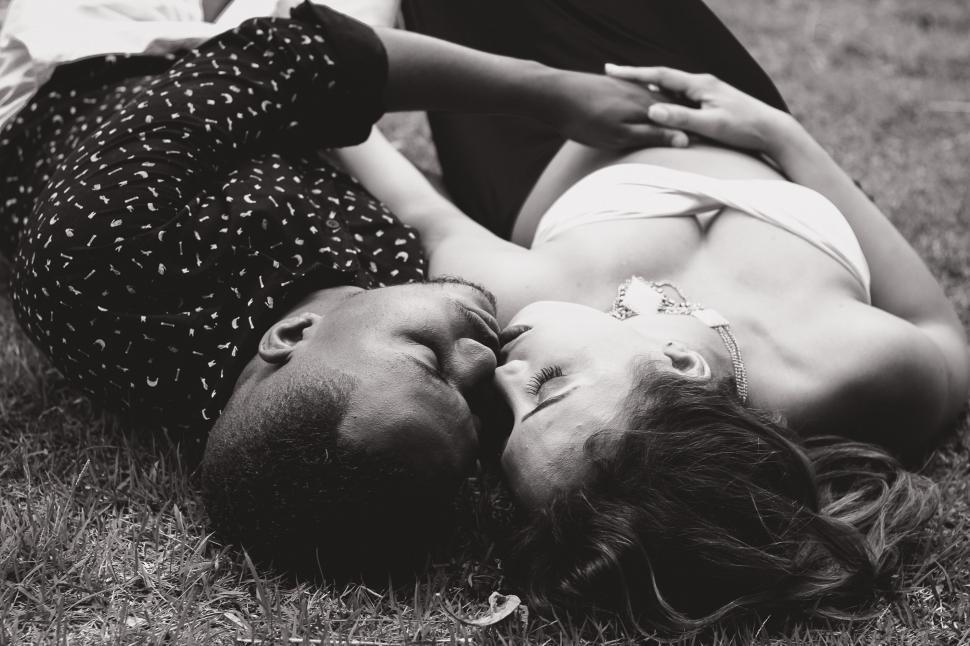 Free Image of Intimate couple sharing a kiss on grass 