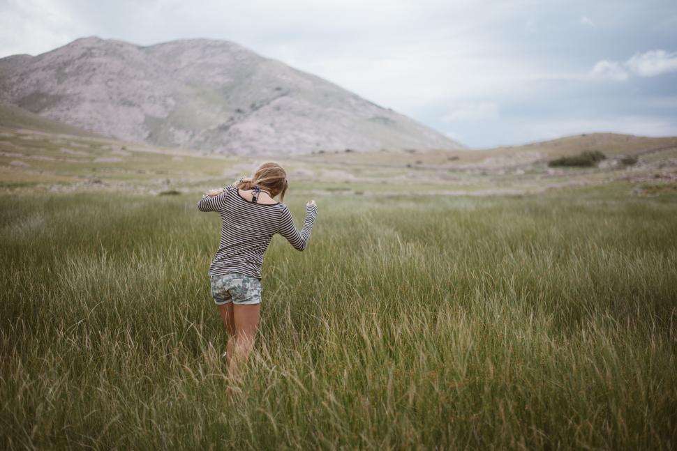 Free Image of Young girl running through grassy field 