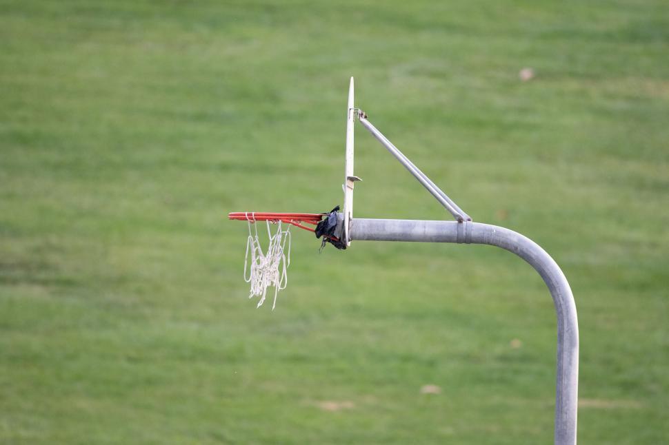 Free Image of Basketball hoop with torn net against sky 