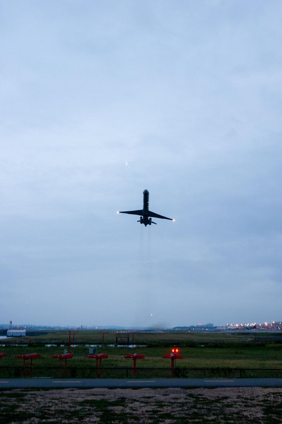 Free Image of Airplane descending against evening sky 