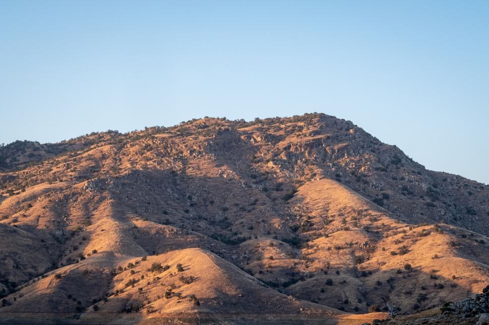 Free Image of Golden hour sunlight on rugged mountain terrain 