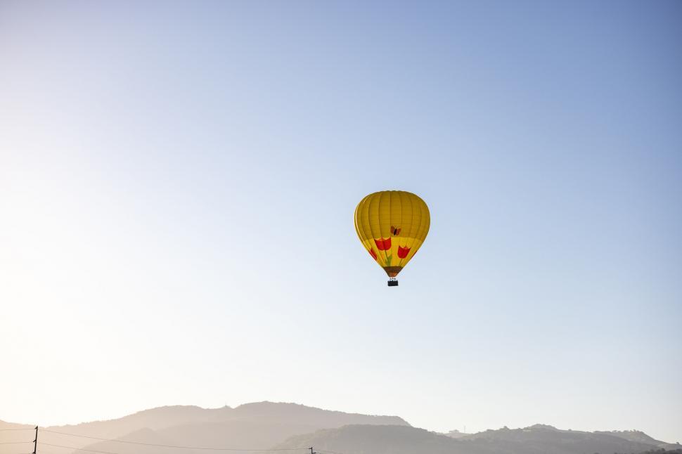 Free Image of Yellow hot air balloon floating in clear sky 