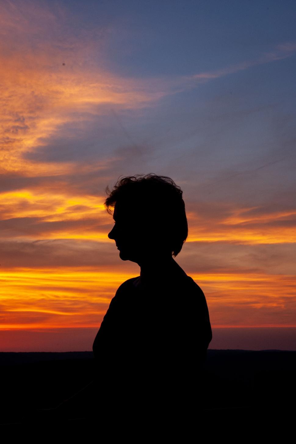 Free Image of Silhouette of a person against vibrant sunset sky 