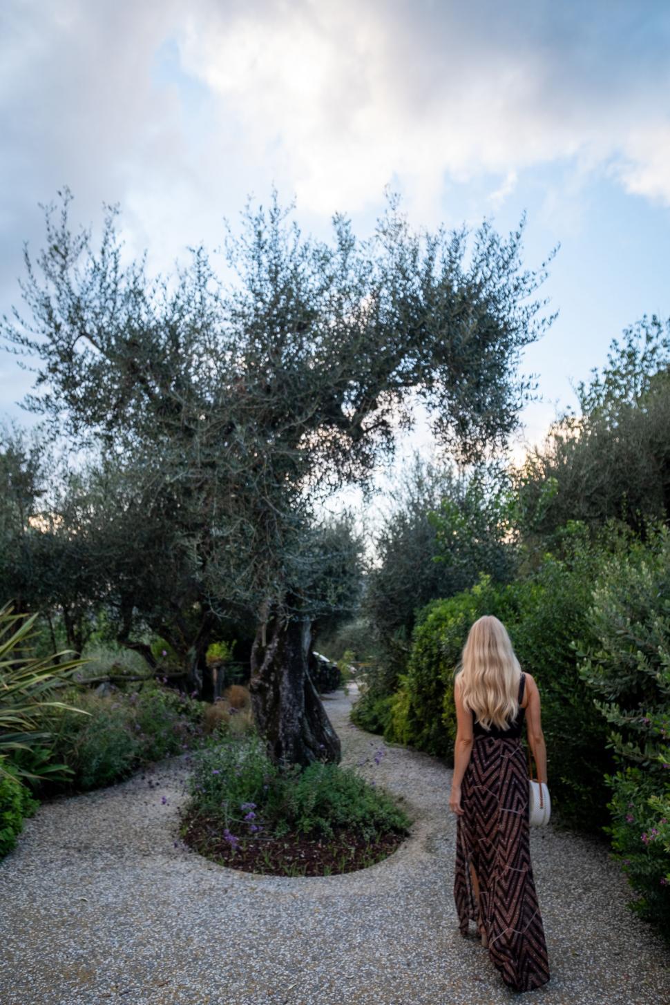 Free Image of Blonde woman walking in a lush garden 
