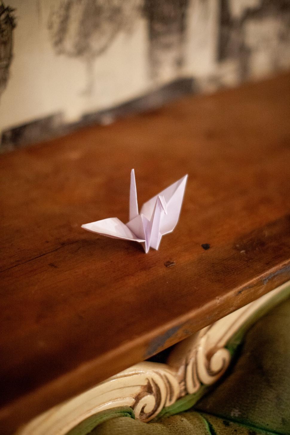 Free Image of Paper origami crane on a wooden table 