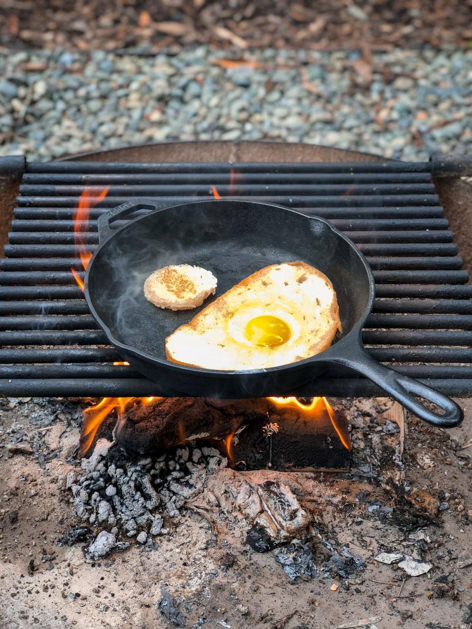 Free Image of Outdoor cooking with fried egg on skillet 