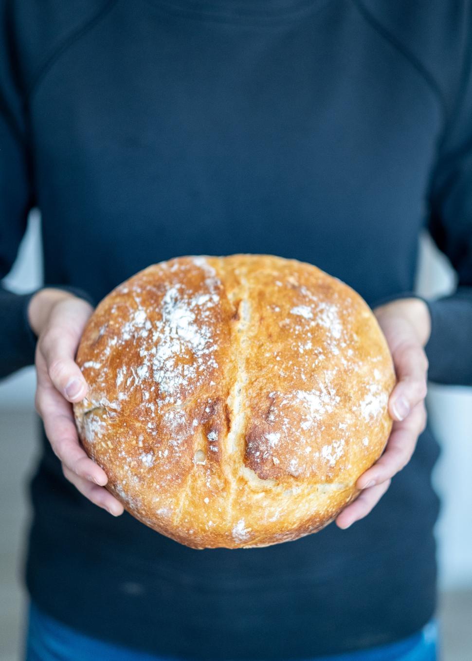 Free Image of Person holding freshly baked homemade bread 