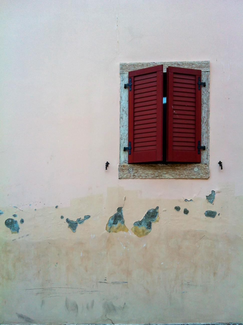 Free Image of Red shutters on a weathered wall in daylight 