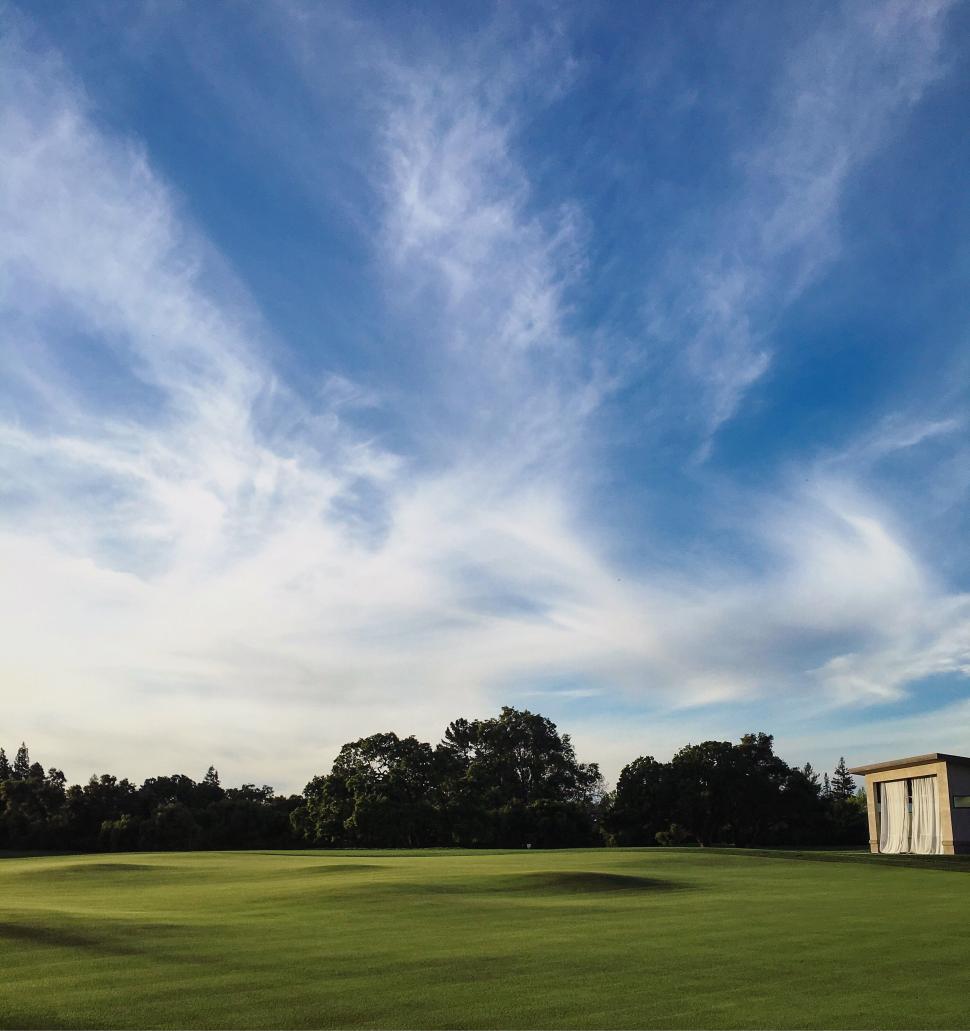Free Image of Lush golf course with blue sky and clouds 