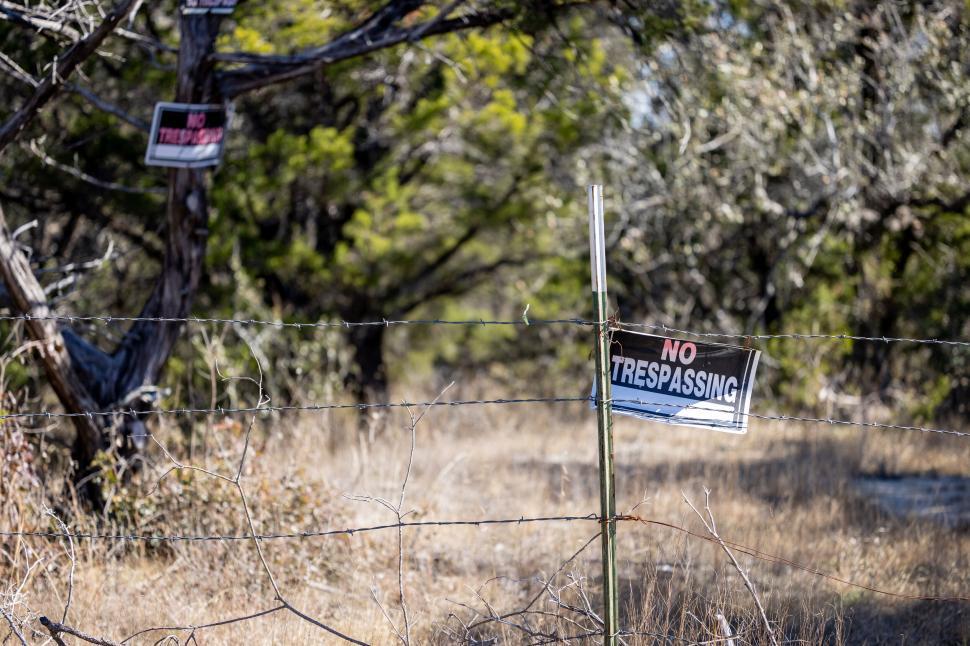 Free Image of No trespassing signs on barbed wire fence 