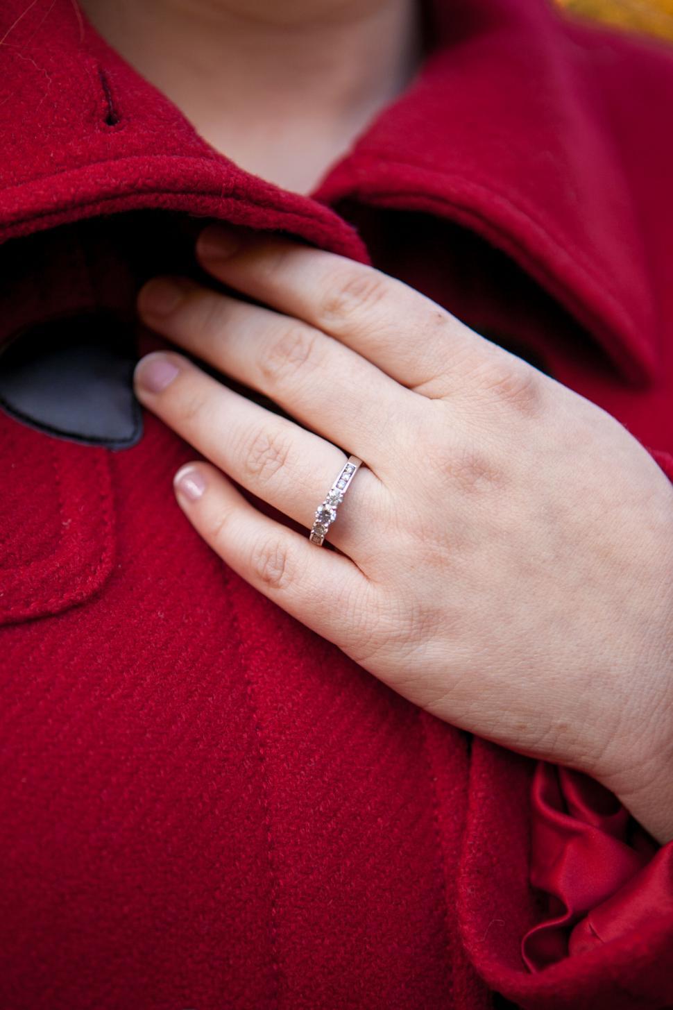 Free Image of Hand with diamond ring on red coat 