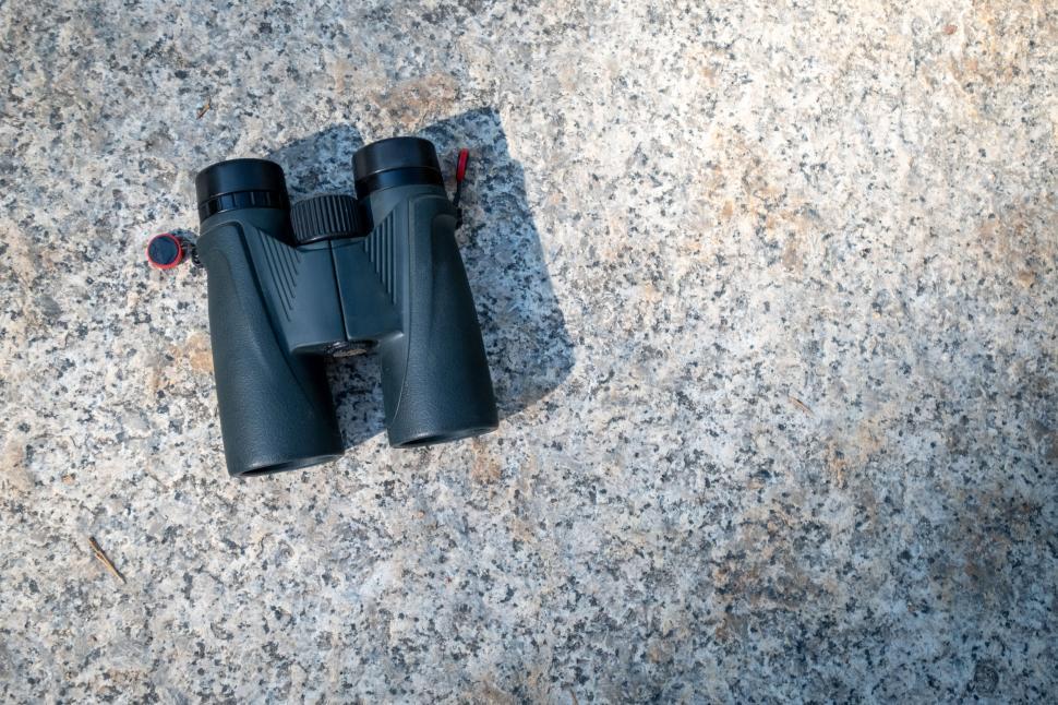 Free Image of Black binoculars on textured rock surface 