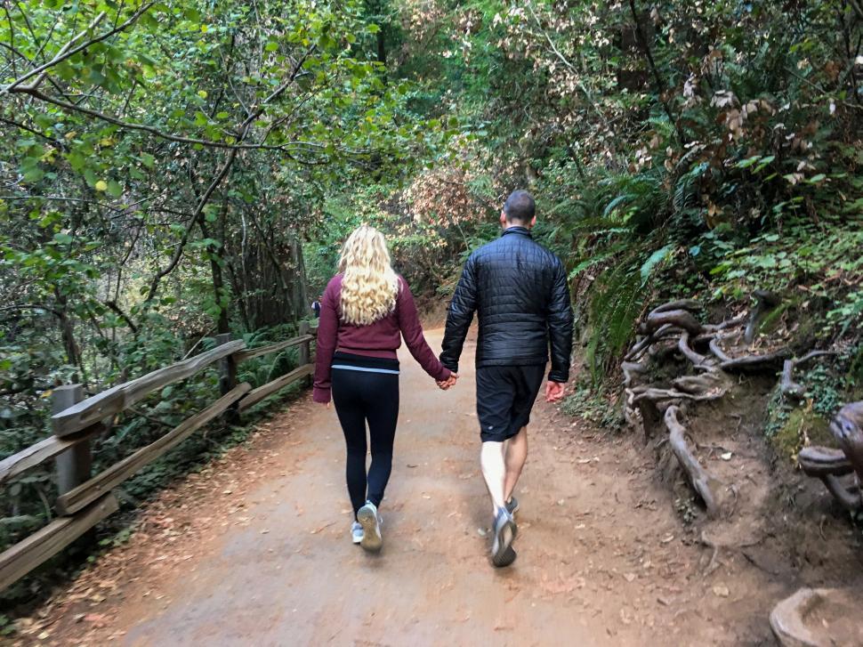 Free Image of Couple walking hand in hand on trail 