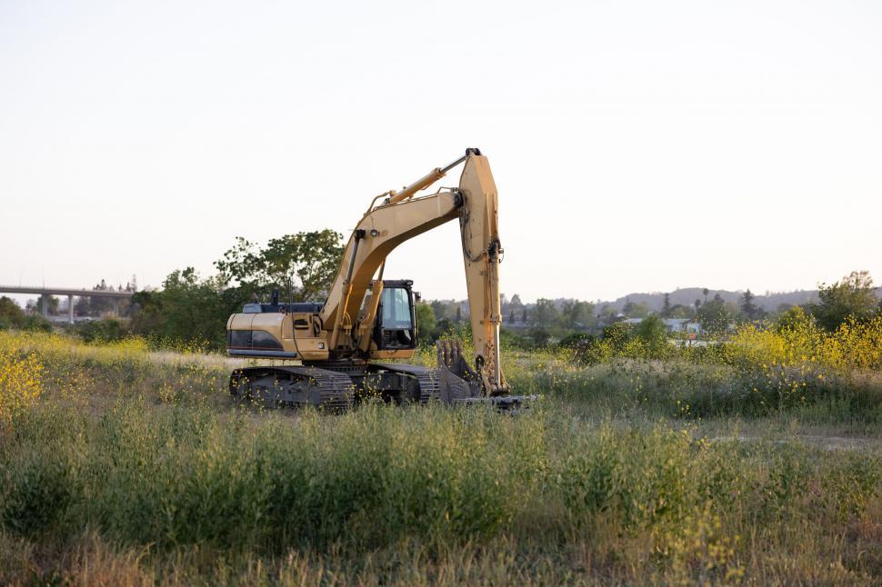 Free Image of Excavator in a field during golden hour 