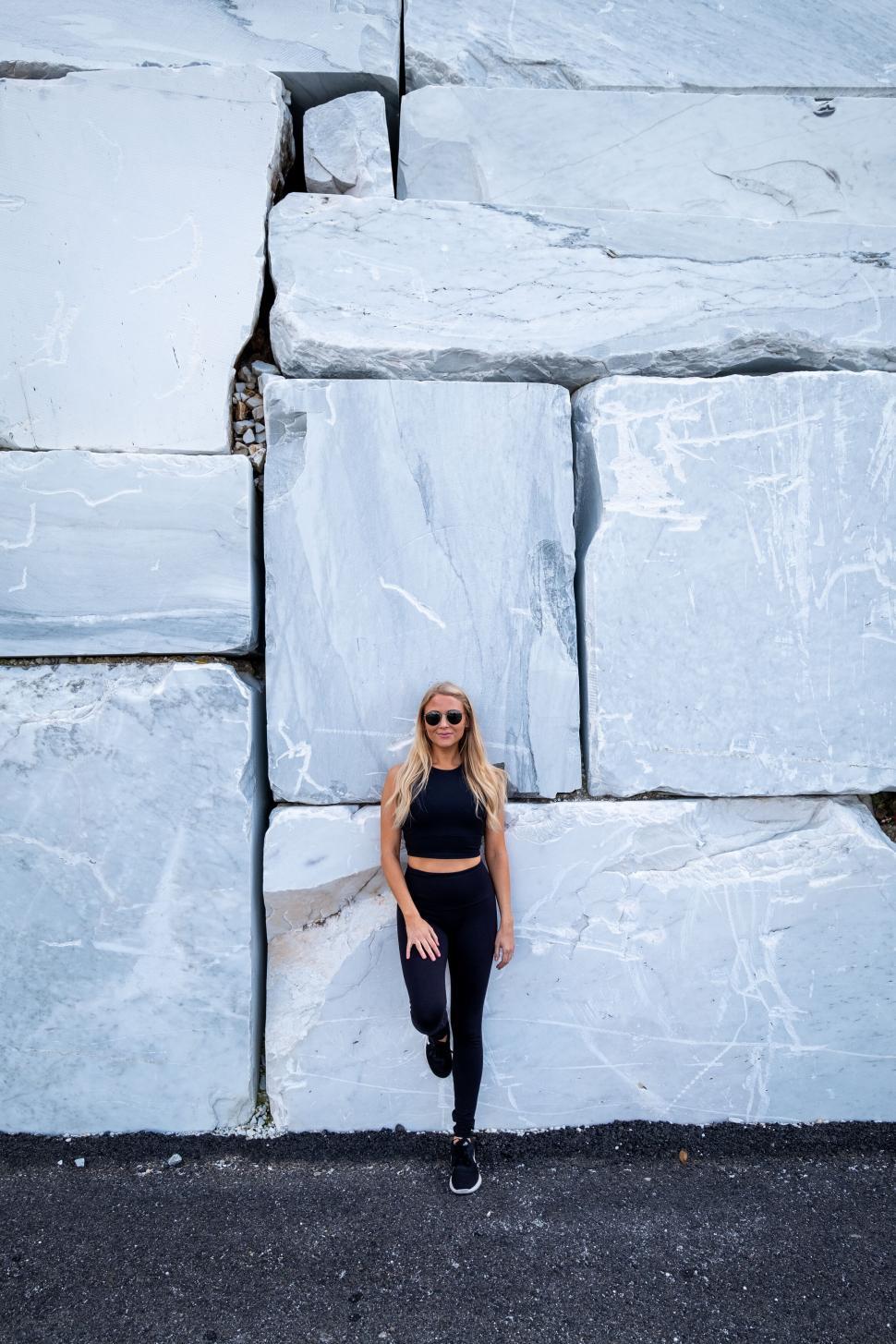 Free Image of Young woman posing against marble blocks 