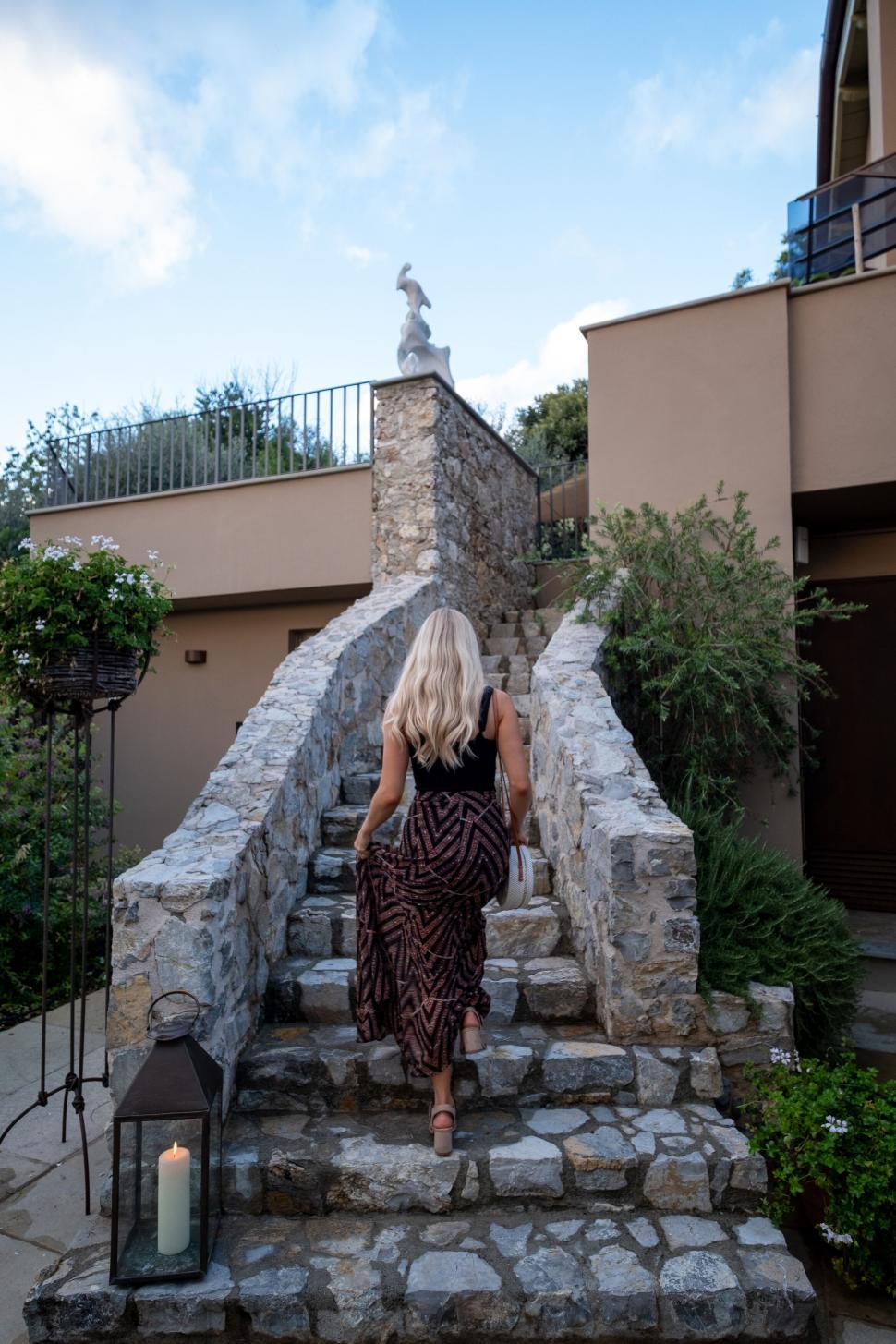 Free Image of Elegant woman walking up stone steps 
