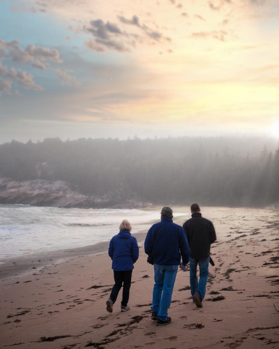 Free Image of Family walking on a beach at sunset 