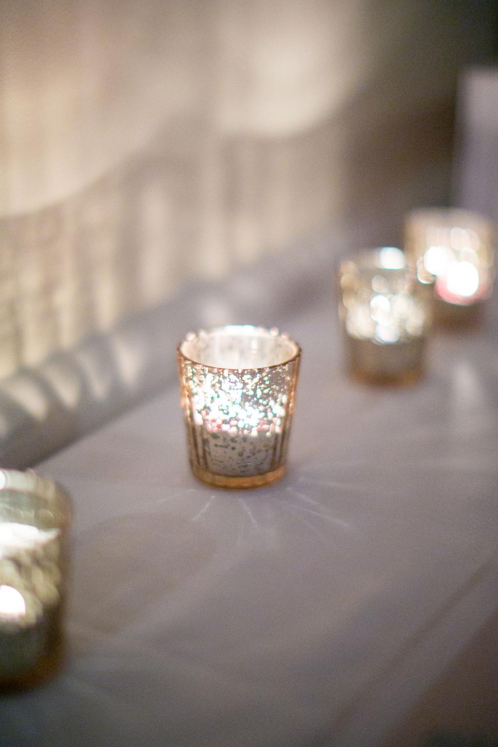 Free Image of Candles glowing in mercury glass votives 