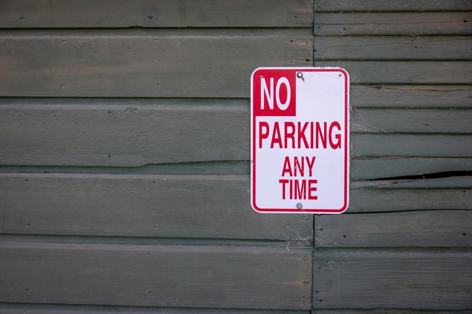 Free Image of Red and white no parking sign on wood wall 