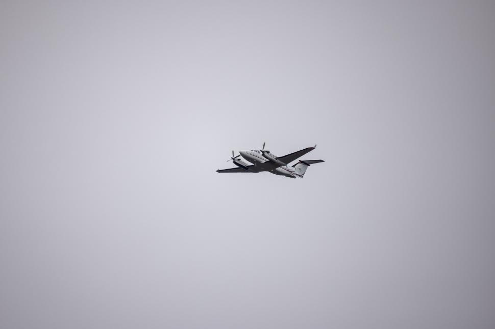 Free Image of Silhouette of a plane flying in a clear sky 