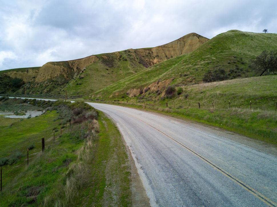 Free Image of Curvy road through rolling green hills 