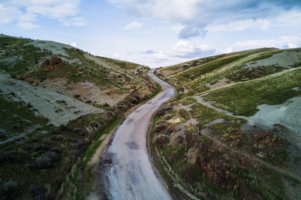 Free Image of Aerial view of winding road through hilly terrain 