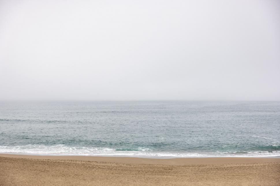 Free Image of Serene oceanfront with foggy horizon 