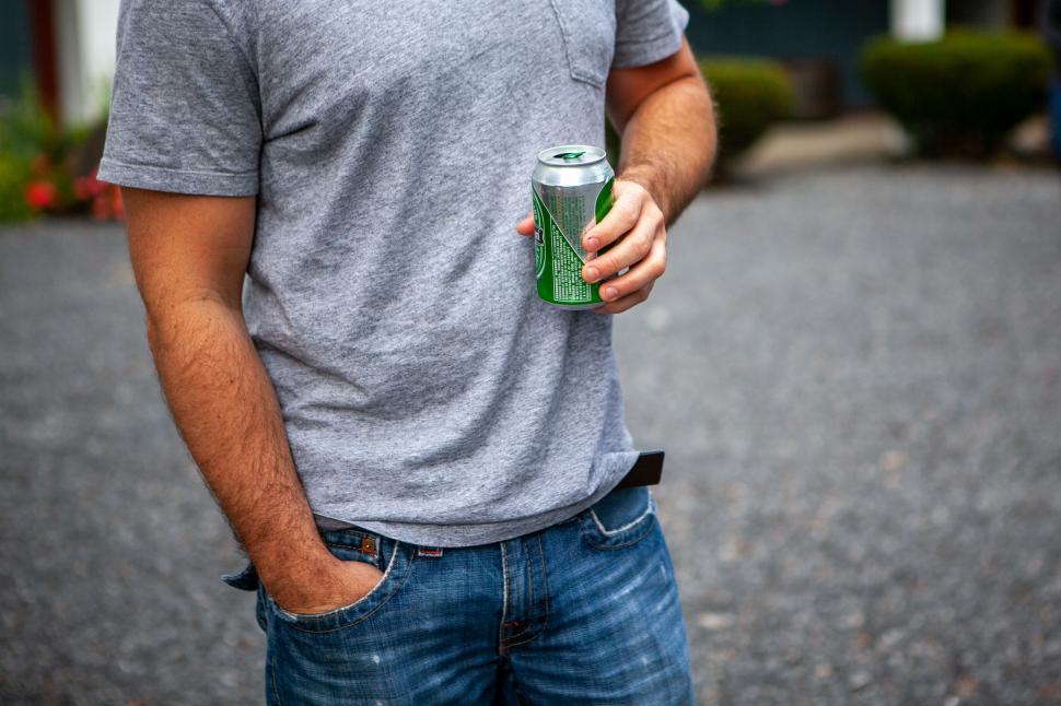 Free Image of Man holding a canned drink casually 