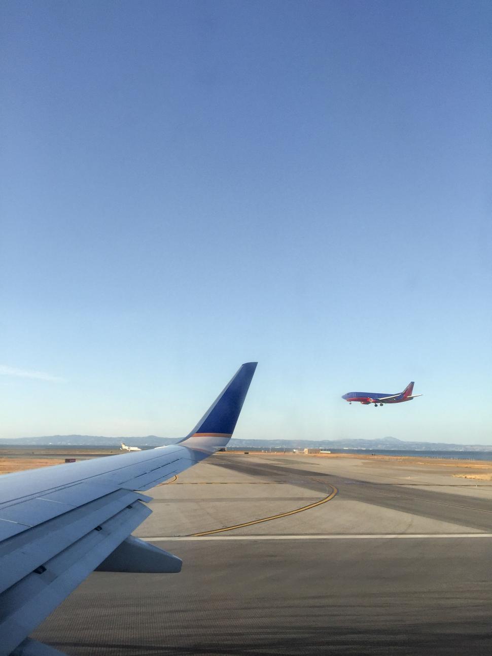 Free Image of Airplane wing and taking off aircraft 