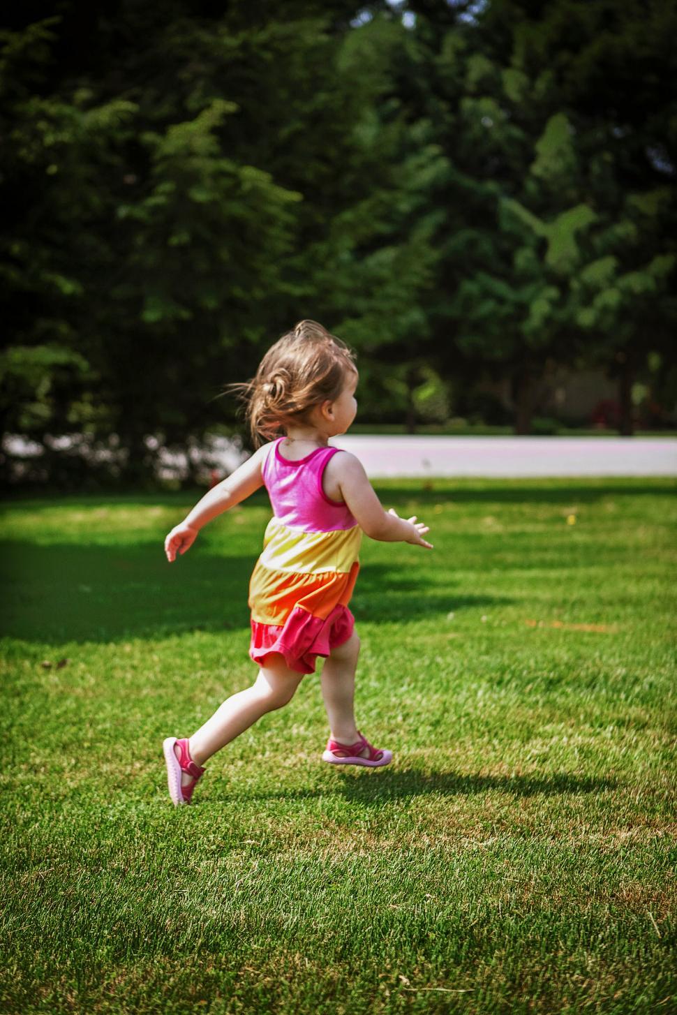 Free Image of Little girl running joyfully in park during summer 