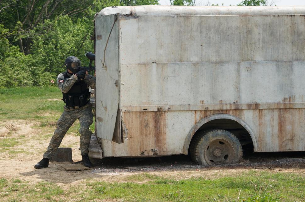 Free Image of Junkyard paintball game with camouflaged man  