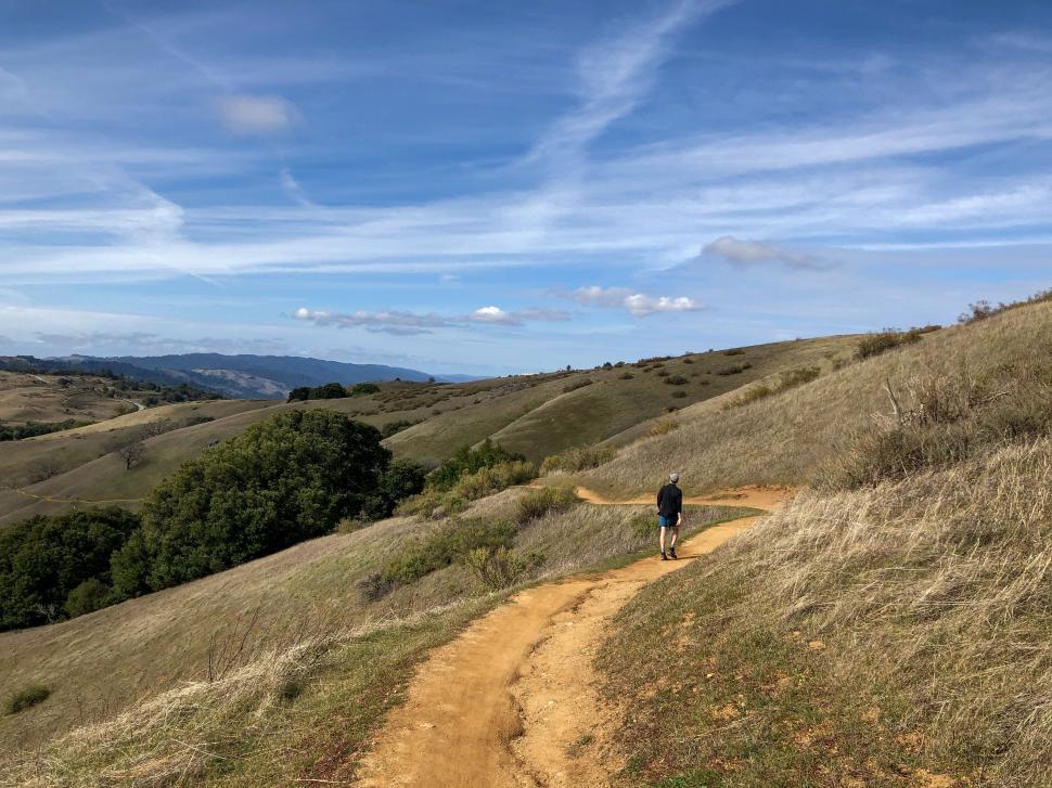 Free Image of Hiker on a trail in rolling hills 