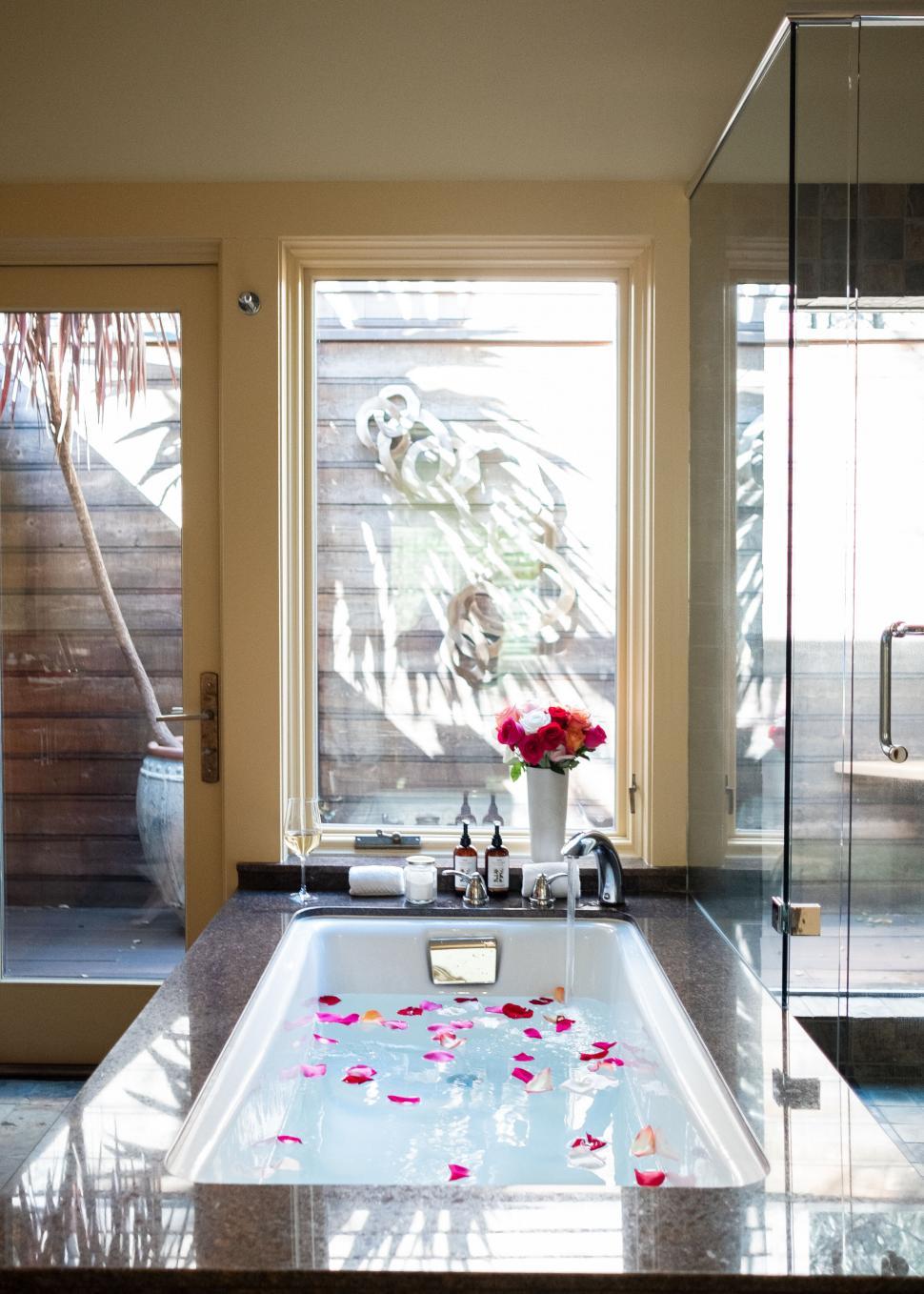 Free Image of Bathroom with rose petals in a tub 