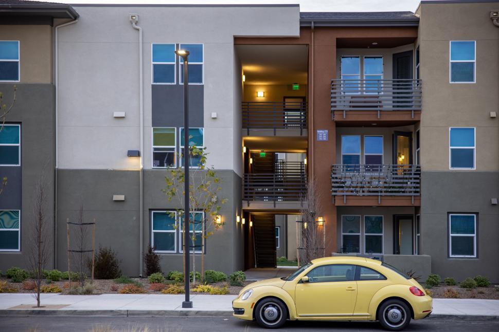 Free Image of Modern apartment building with yellow car 