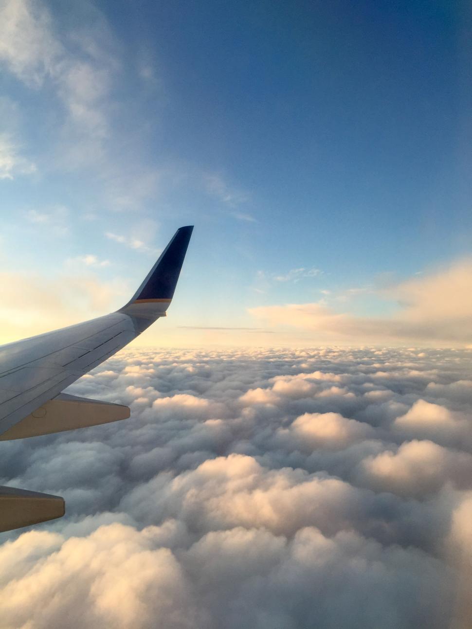 Free Image of Aerial view from airplane window above clouds 