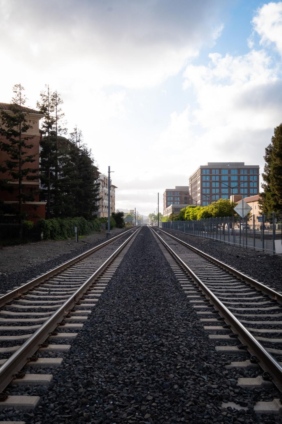 Free Image of Railroad tracks leading into urban skyline 