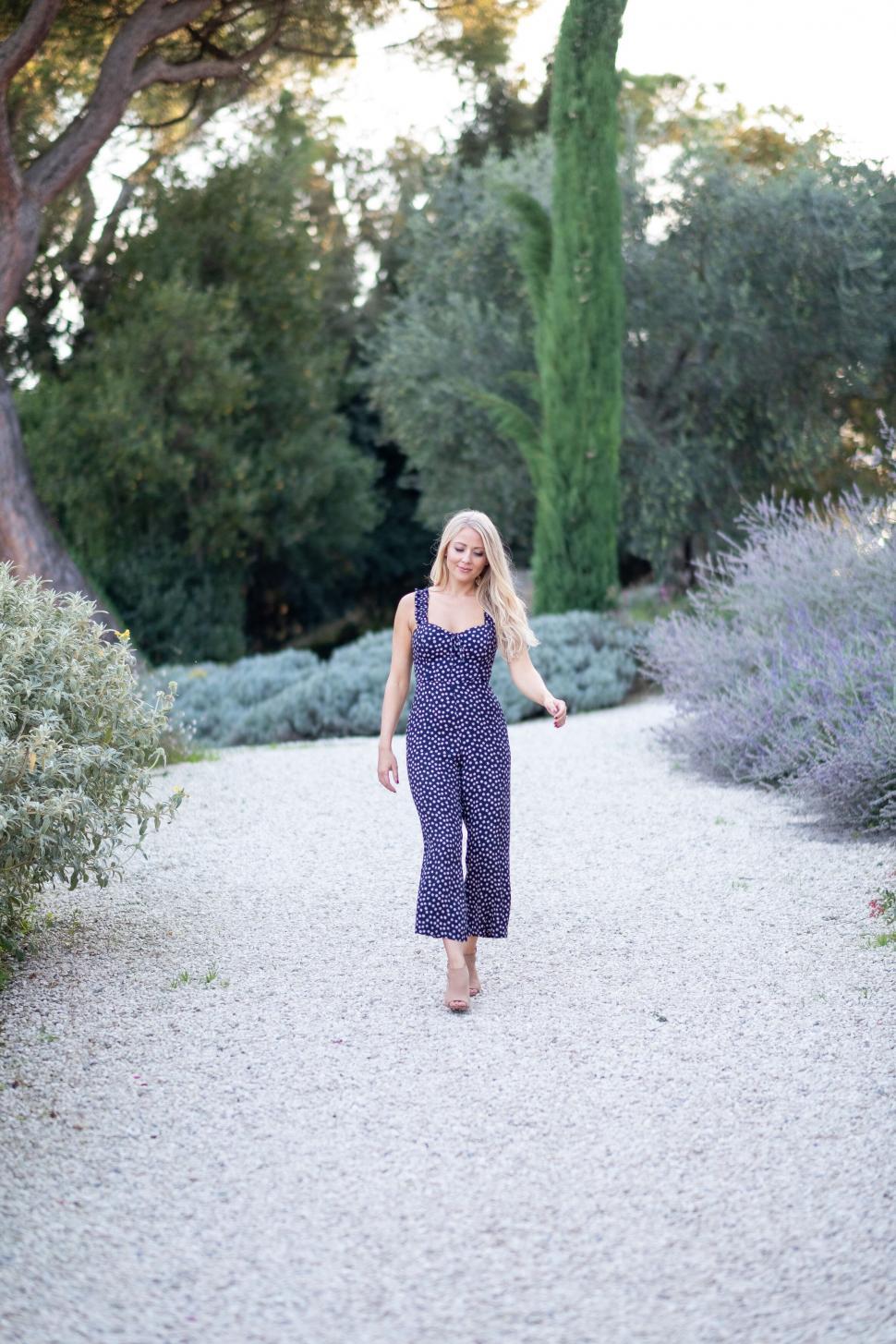 Free Image of Woman strolling in a Mediterranean garden 