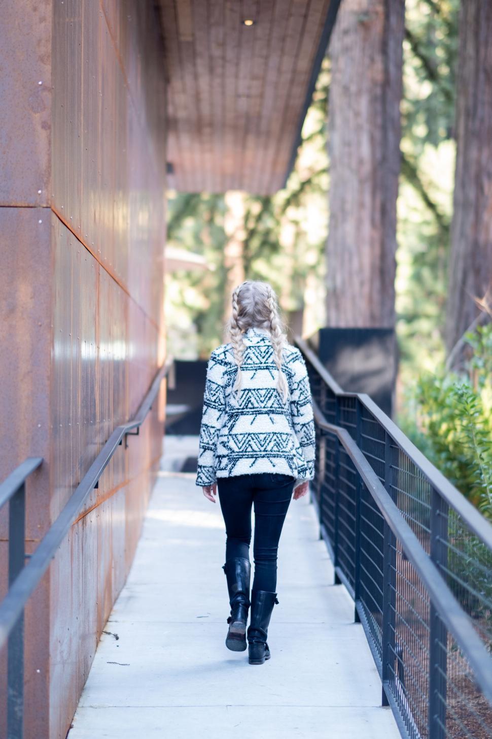 Free Image of Woman walking along a forested pathway 