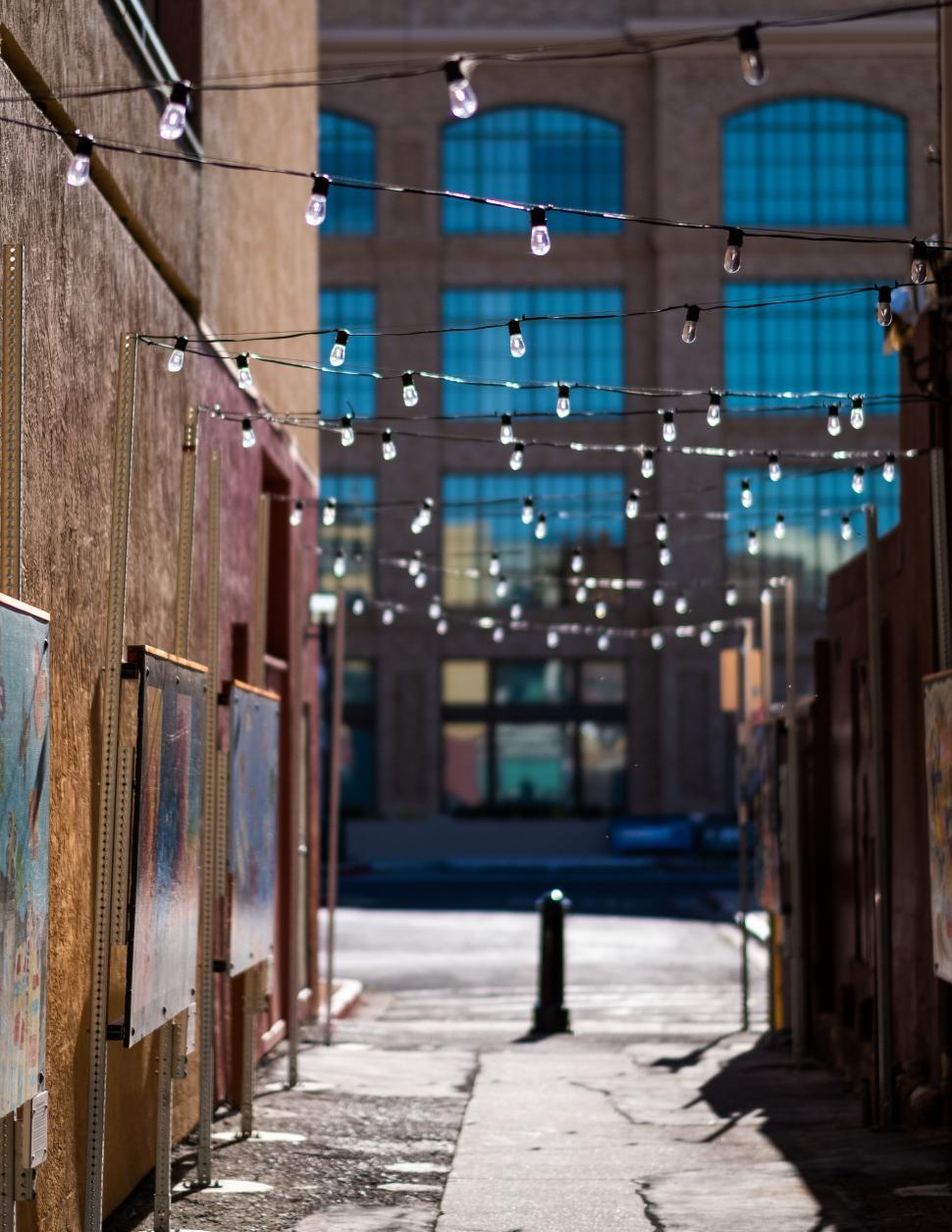 Free Image of Urban alley with hanging lights and artwork 