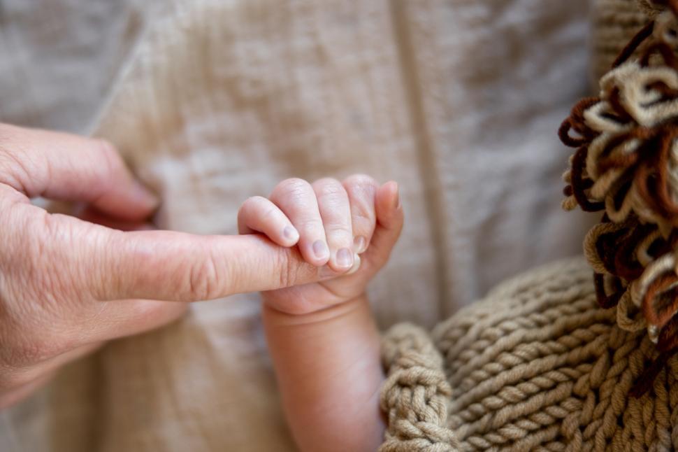 Free Image of Tiny baby hand holding an adult s finger 