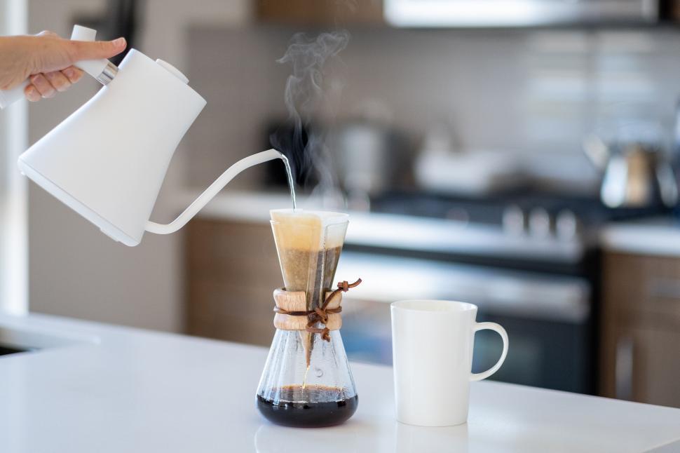 Free Image of Pouring hot water into a coffee maker in a kitchen 