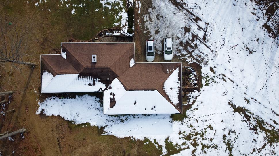 Free Image of Aerial view of snowy house and cars 
