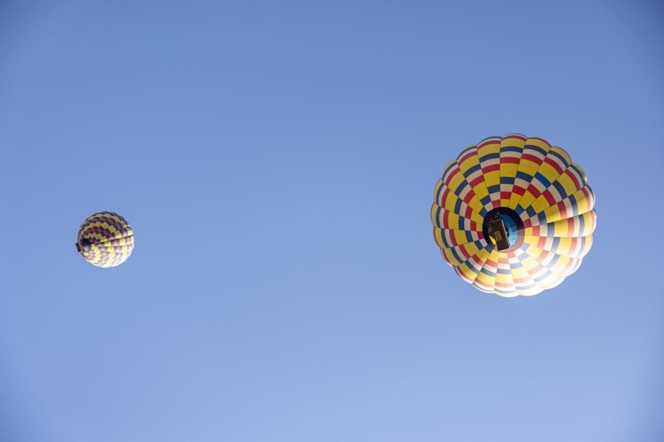 Free Image of Hot air balloons floating in bright blue sky 