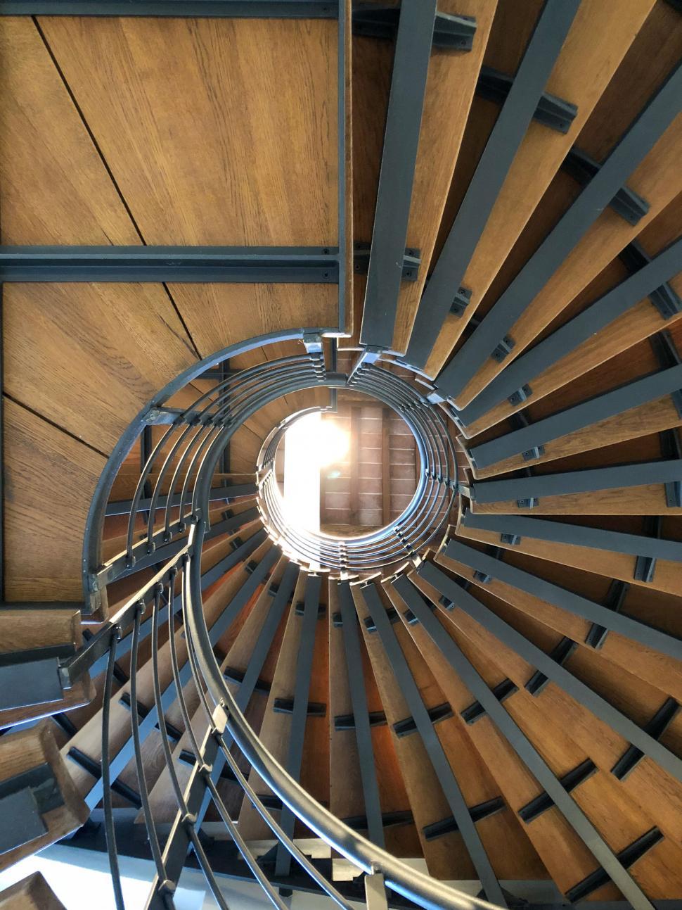 Free Image of Spiral staircase with wooden steps and metallic banister 