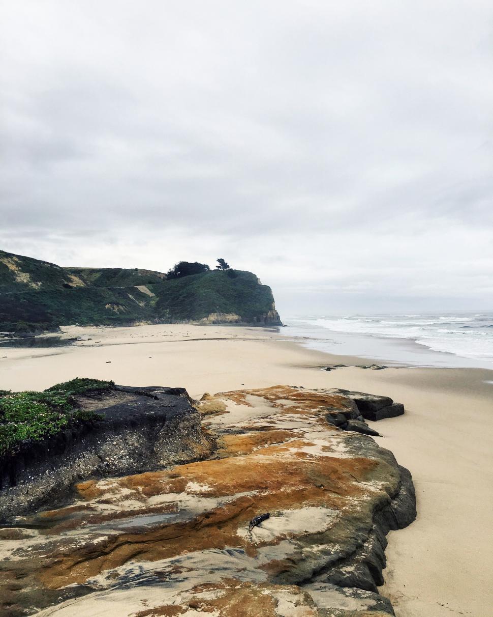 Free Image of Rocky beach with overcast sky and ocean 