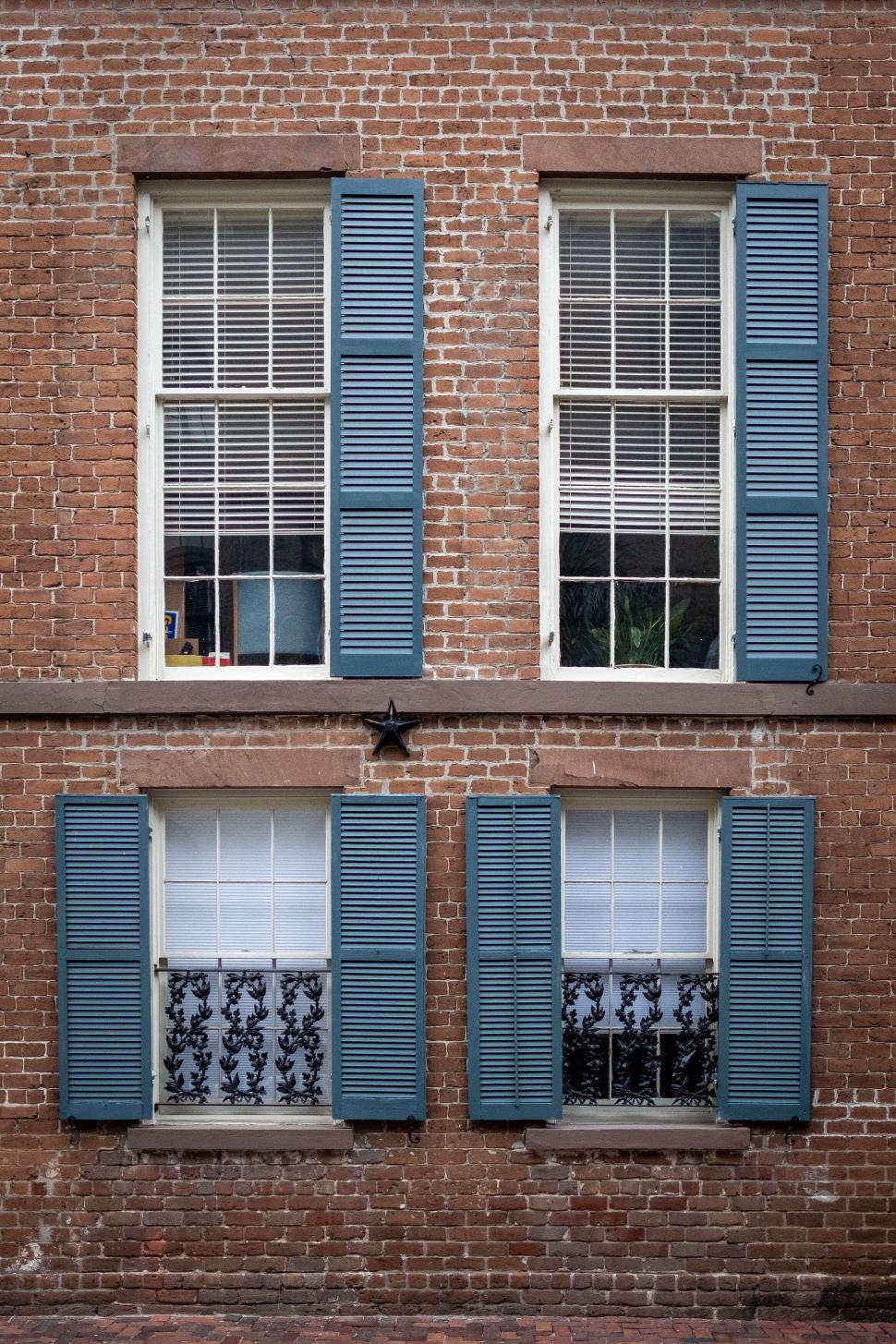 Free Image of Vintage brick building with blue window shutters 