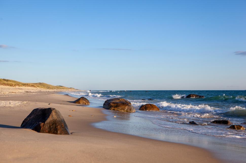 Free Image of Calm beach scene with rocks and gentle waves 