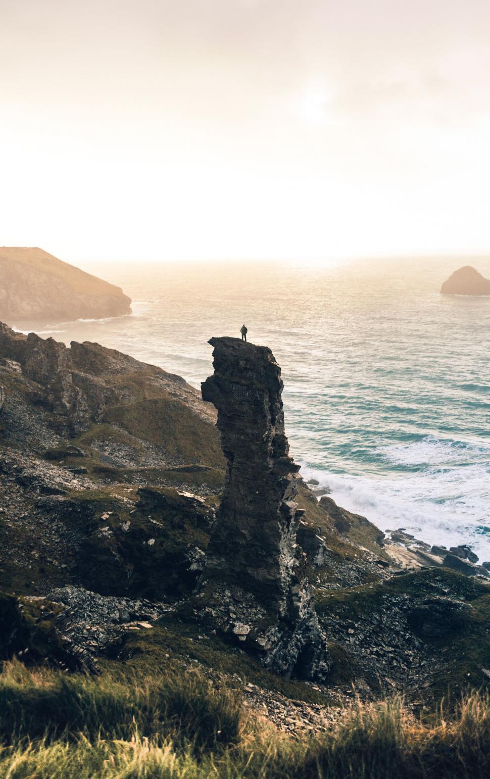 Free Image of Person on cliff above the sea at sunset 